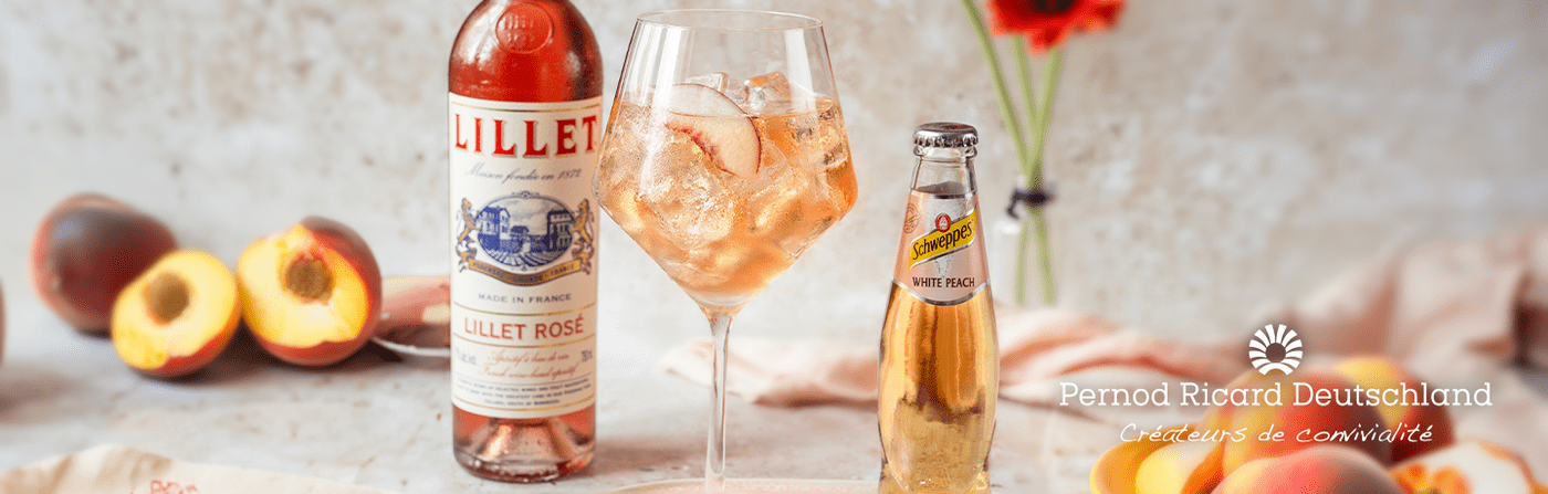 Eine Flasche Lillet Rosé und eine Flasche Schweppes White Peach dazwischen ein Getränk im Weinglas mit Eis drumherum Pfirsiche und über dem Bild der Schriftzug Pernod Ricard Deutschland